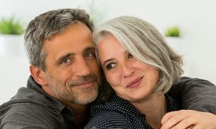 Simbolična slika: par v poznih srednjih letih. Na levi: gospod s kratkimi, rahlo sivimi lasmi in modrimi očmi, v temno sivi srajci. Gleda naprej, obrnjen s telesom nekoliko v levo, na svoji desni objema žensko približno njegovih let, s sivimi, malce daljšimi, ravnimi lasmi in rjavimi očmi, v črni bluzi z majhnimi belimi pikami. Pogled ima uperjen v levo. Oba z rahlim nasmeškom na obrazu, videti zadovoljna in srečna. 