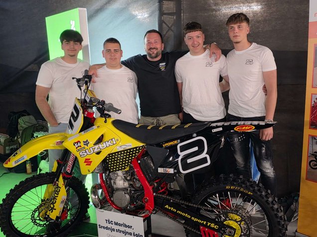 Zaključni dogodek Mojstri prihodnosti 3. junija 2026 v Ljubljani: skupina štirih dijakov srednje strokovne šole skupaj z mentorjem v svoji sredi pozira ob razstavljenem prenovljenem motornem kolesu.